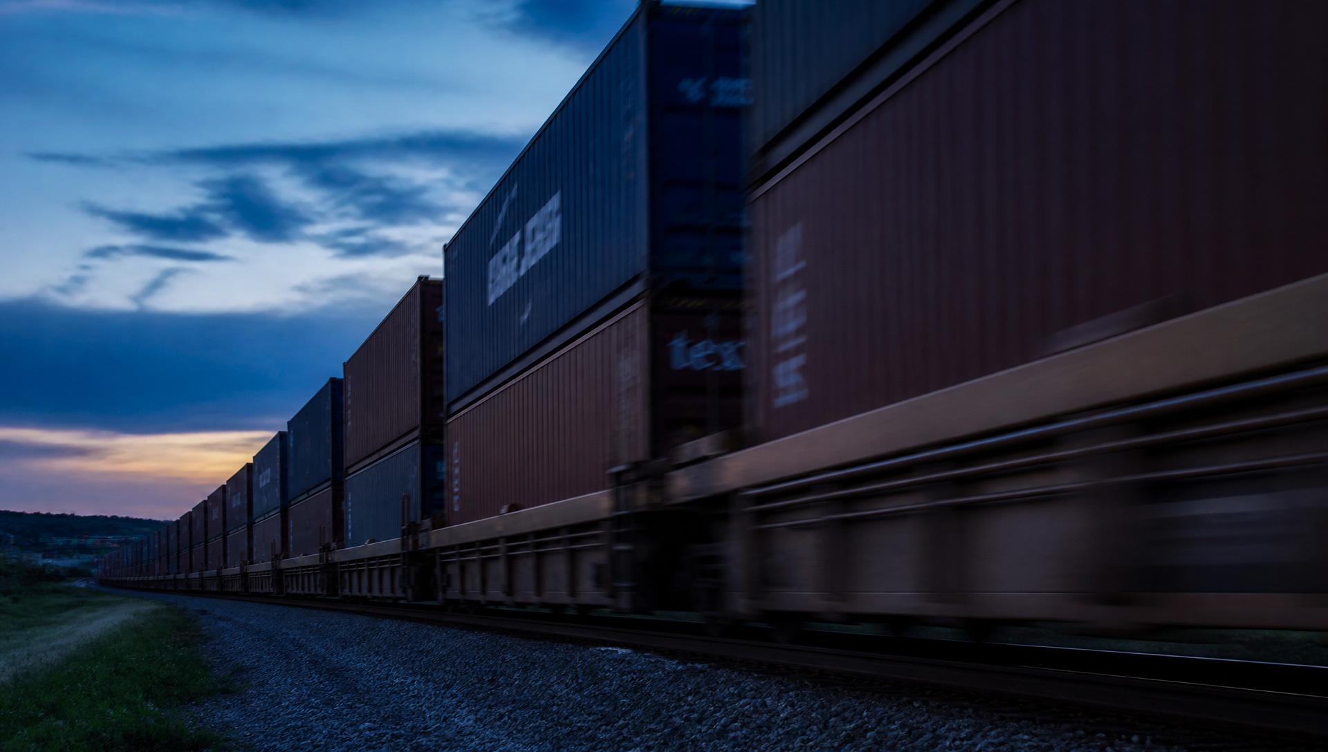 Container freight train moving through the landscape at dusk